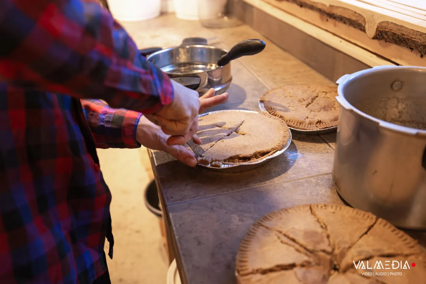 Une tourtière au millet qu'on tranche, sur le comptoir de la cuisine.
